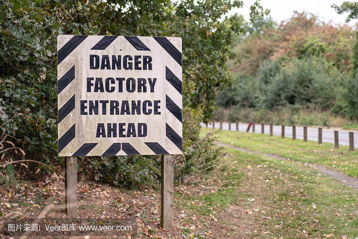 危险工厂入口前方英国道路上的警告路标